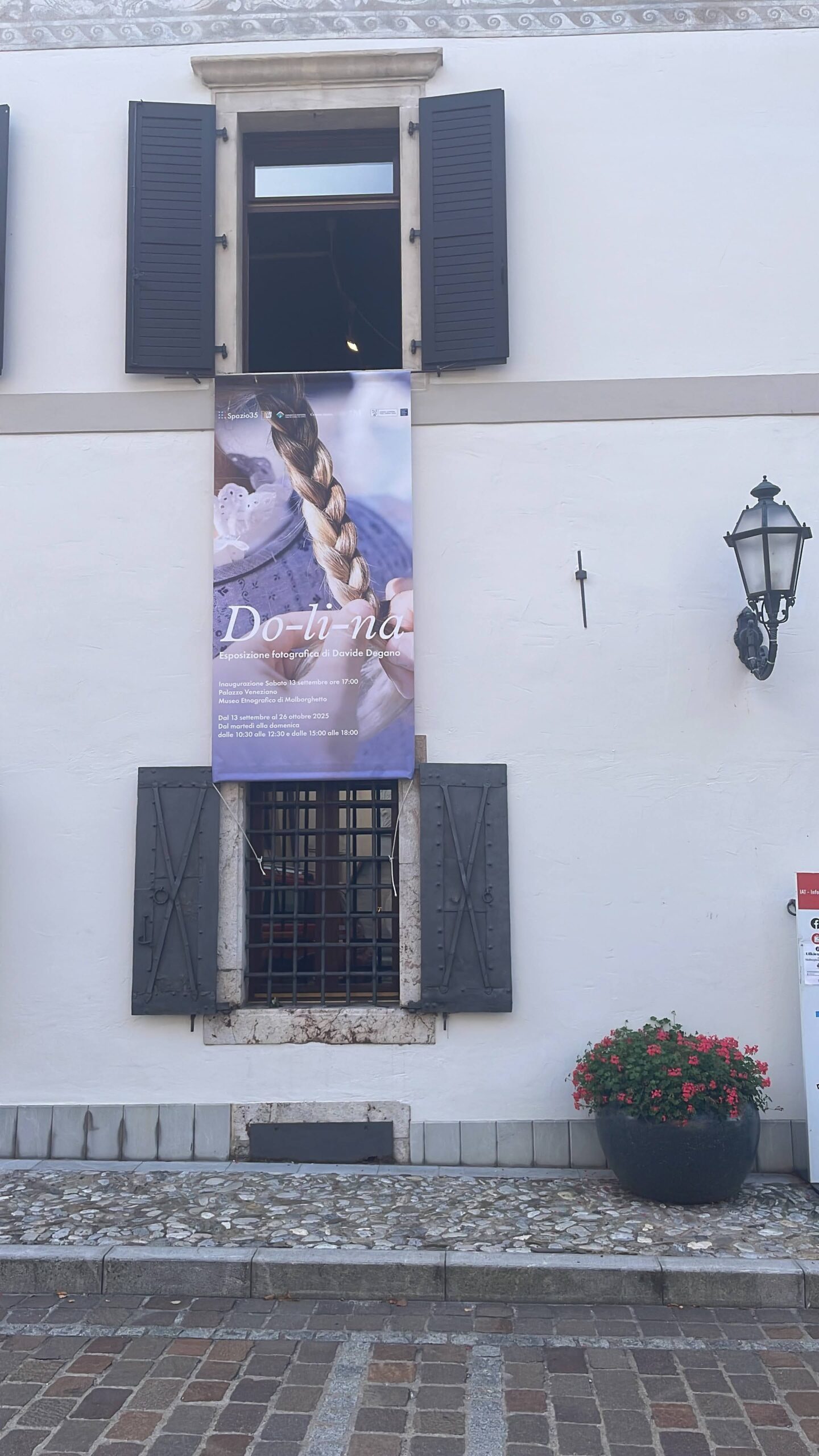 Do-li-na — il banner della mostra sulla facciata di Palazzo Veneziano, Malborghetto